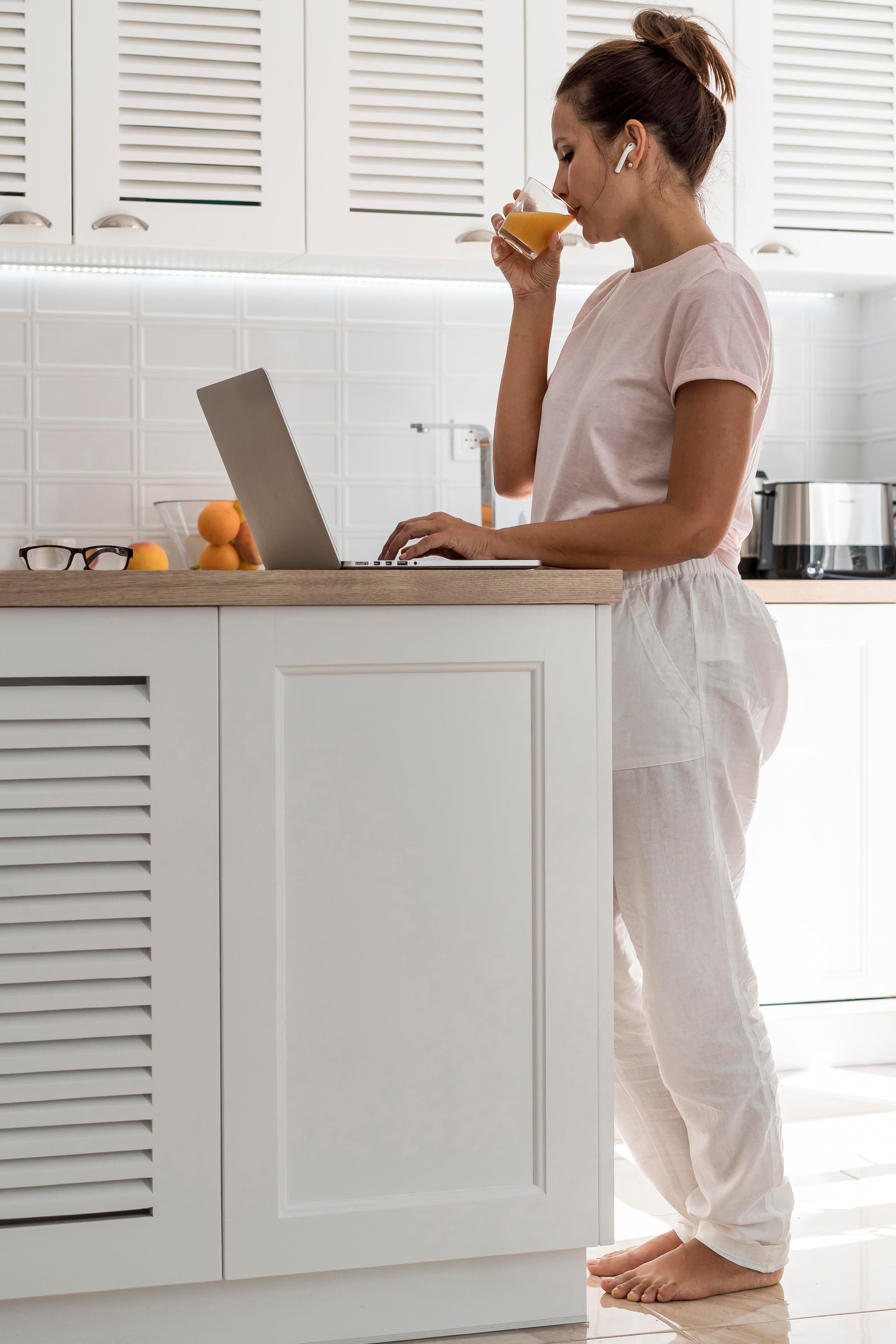 Woman working while standing at a kitchen counter