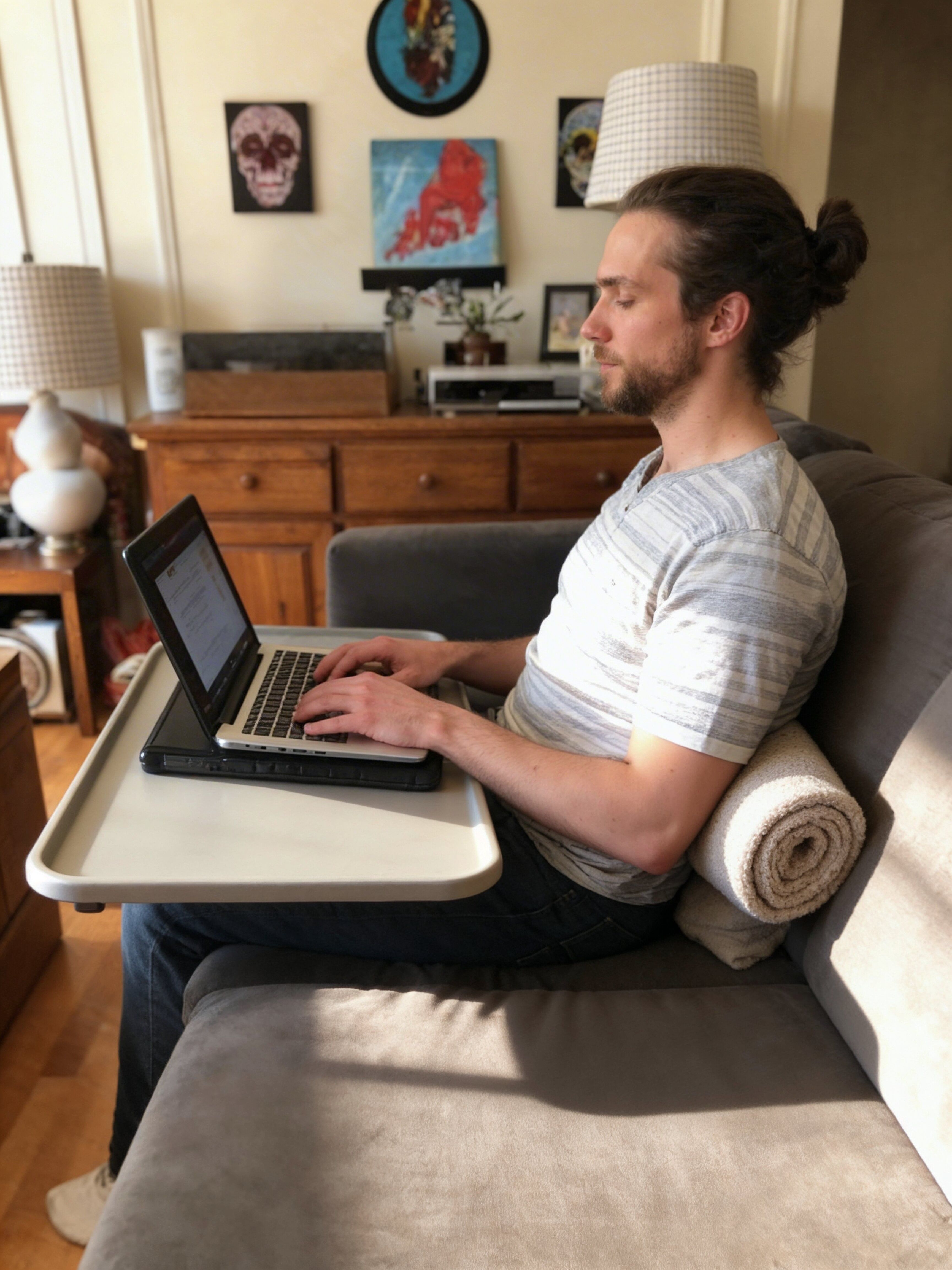 Person working on a couch with laptop support