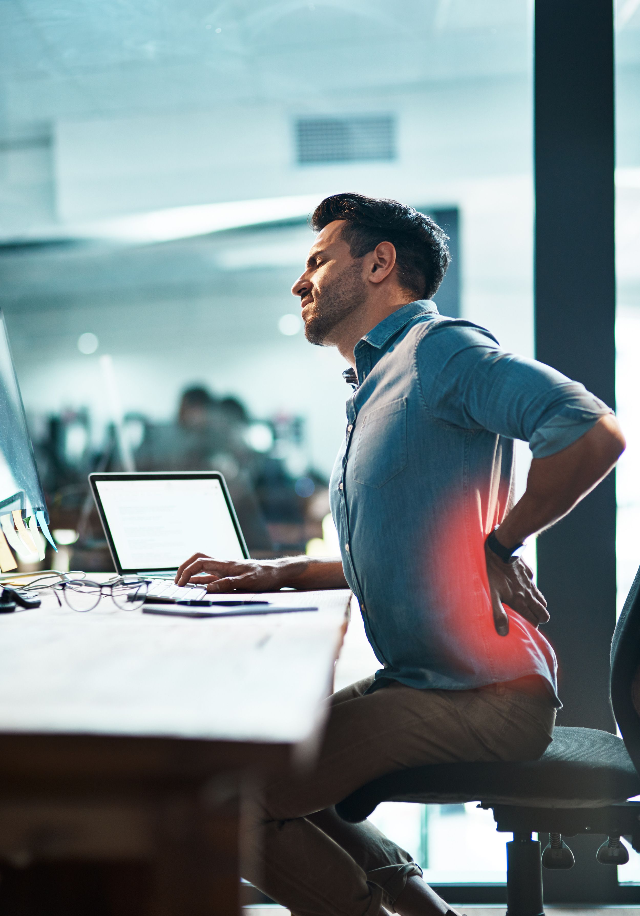 Office worker holding lower back in pain